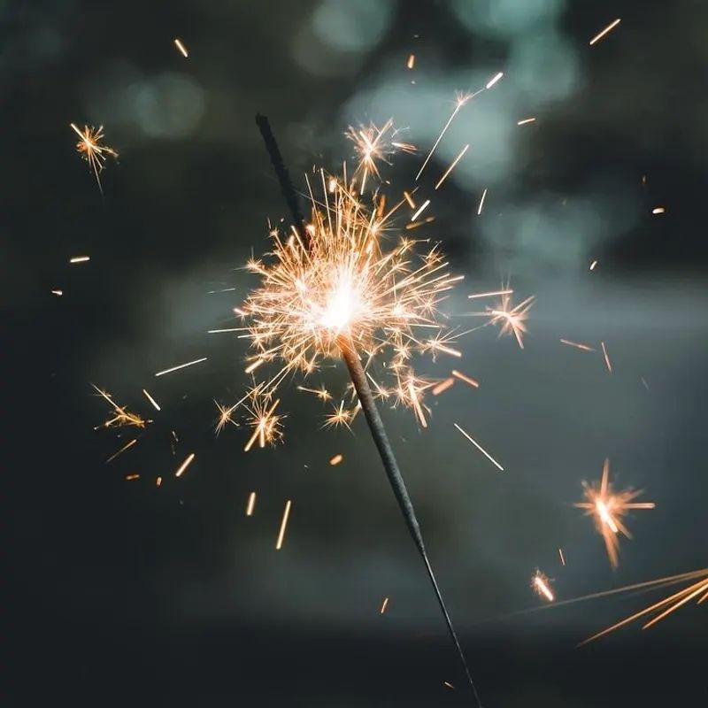 Bright sparkler firework emitting gold sparks