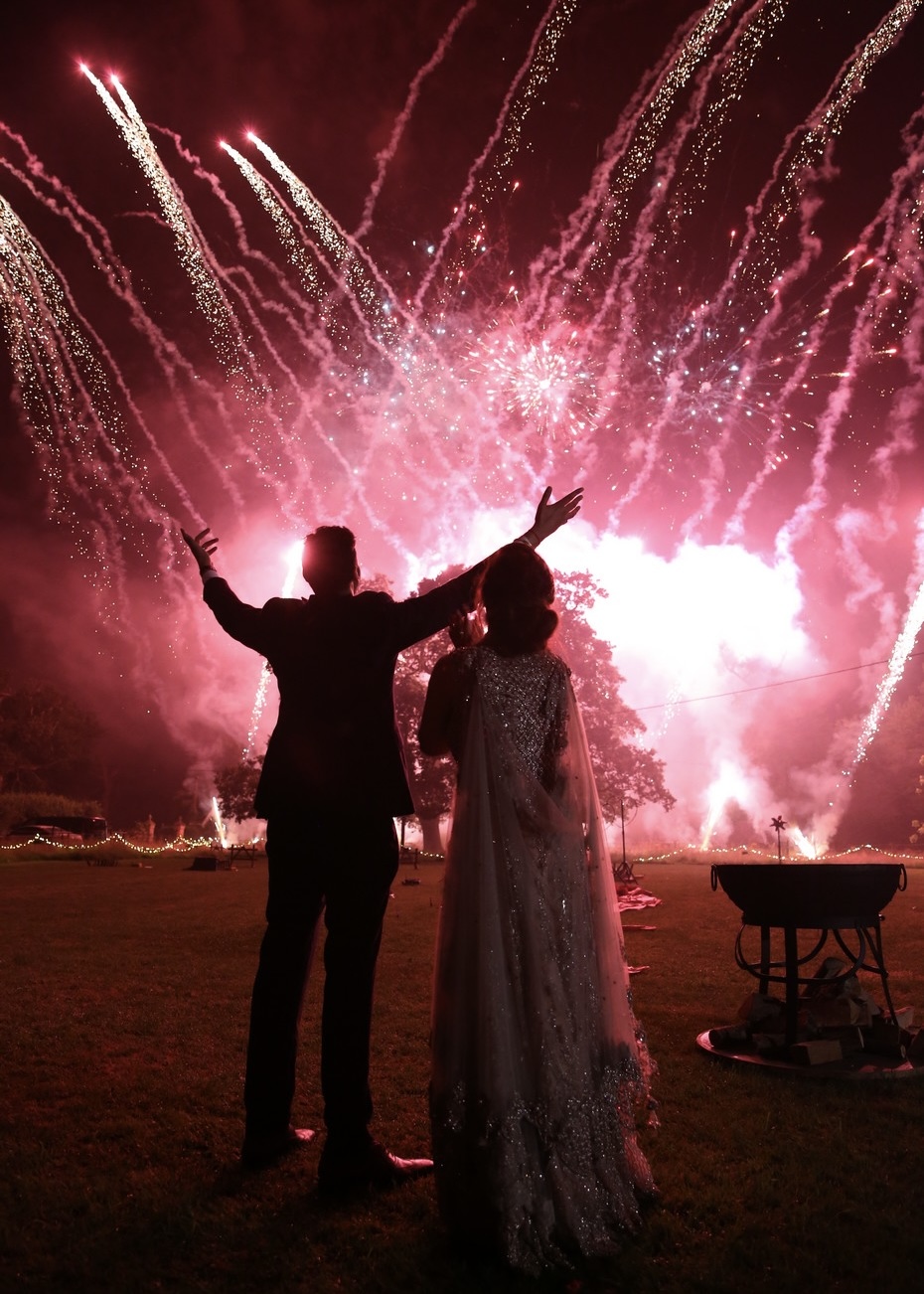 Couple enjoying a wedding fireworks display at night