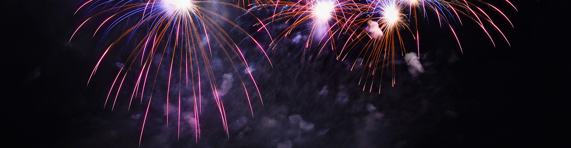 Colorful fireworks bursting in the night sky during a celebration.